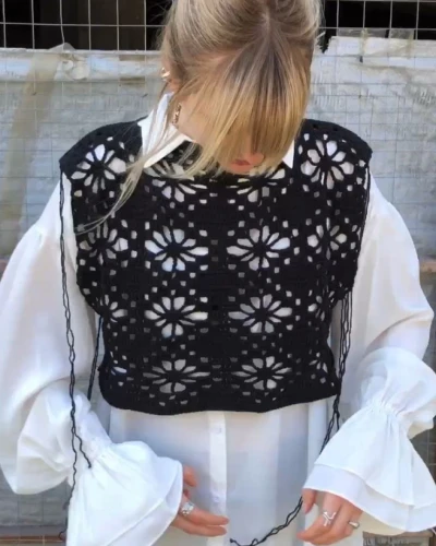 Back view of black floral crochet top showing scalloped hem and floral crochet pattern.