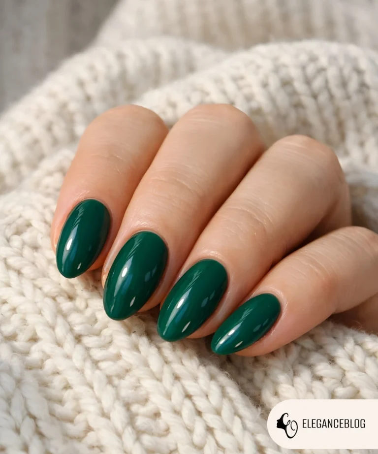 Emerald green winter nails with natural glossy gel finish on relaxed female hand over knit fabric