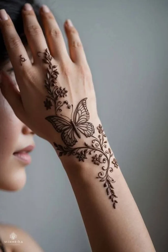 Elegant butterfly mehndi design with flowing wings, dotted accents, and ornamental henna details on skin.