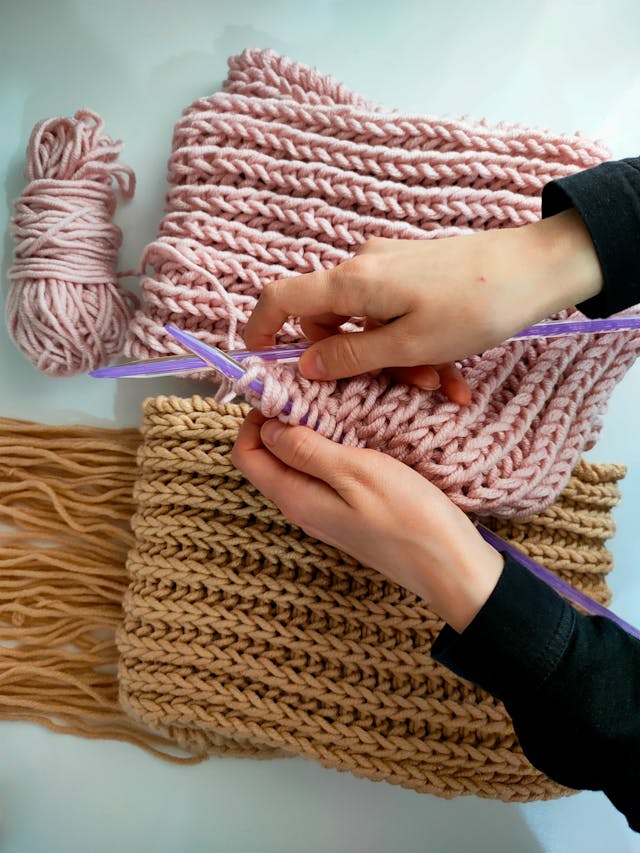 woman crochets sleeves of a sweater