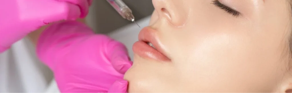 Woman receiving lip filler injection in a cosmetic clinic